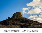 A LARGE ROCK FORMATION ON A HILL WITH A METAL STAR FRAME AND FLAG IN CASTLE ROCK COLORADO