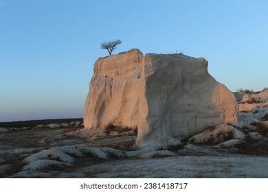 A large rock formation with a tree on top - Powered by Shutterstock