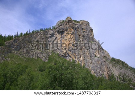 A large rock mass protruding from the coniferous forest. Altai, Siberia, Russia.