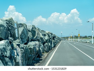 Large Rocks On A Sea Wall Construction And Road At A Marina In An Australian City