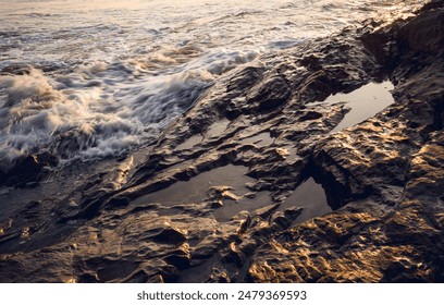 A large rocks surrounded by waves of the ocean