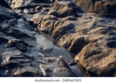 A large rocks surrounded by waves of the ocean