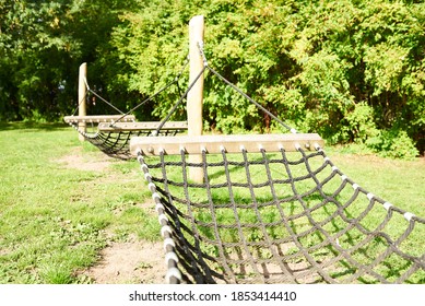 Large Rope Hammock Hanging On Poles In A Backyard