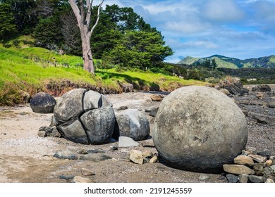 Large round boulders on a sandy beach by the hill. Koutu boulders, Hokianga Harbour, New Zealand. - Shutterstock ID 2191245559