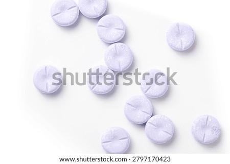 Large, round purple chewable tablets on a white background.