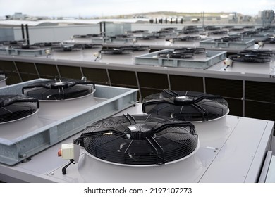 Large row of industrial condensers with fans on roof used in air conditioning, refrigeration, heat pump systems, green energy future concept - Shutterstock ID 2197107273