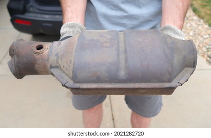 A large and rusty used catalytic converter that is removed from the vehicle. Converts toxic gases and pollutants from internal combustion engine exhaust. - Shutterstock ID 2021282720