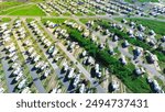 Large RV park campsite long row of recreational vehicles trailers boats tall palm trees in South Padre Island beach Gulf Coast shoreline, aerial view campers basecamp with power hookup, Texas. USA