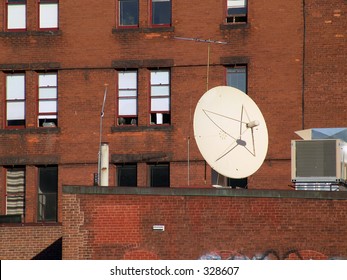 large satellite dish sits on roof outside brick housing unit in northampton, massachusetts, new england