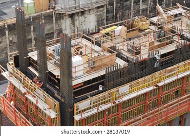 Large scale construction site featuring the foundation of what will be a large skyscraper.