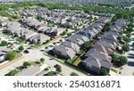 Large scale master planned community row of suburban residential houses in Bartonville and Argyle, Denton County, Texas, two story homes with shingle roofing, compact backyard, lush green trees. USA