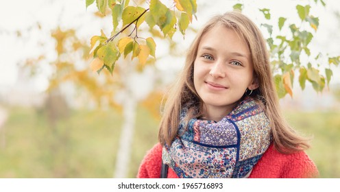 Large Scale Portrait Of Young Woman With Candid Look And Smile Standing Outside