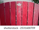 Large scale red coloured Muskoka Canada 150 chair set up at the Brockville Municipal Marina.