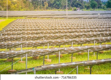 Large Scale Solar Farm, Mega Photovoltaic Power Plant In Green Grass Field.