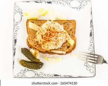 Large Scoop Of Tuna Salad Sprinkled With Paprika On Whole Grain Toast With Sweet Gherkin In High Contrast Black And White Setting.