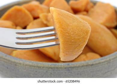 A Large Serving Of Cut Canned Yams In An Old Bowl With A Single Piece On A Fork In The Foreground.