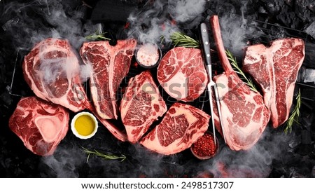 A large set of meat steaks cooked on an open fire. Barbecue. Tomahawk steak, Ribeye, Ossobuco and T-bone steak.