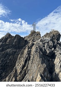 Large sharp rocks with a lighthouse.