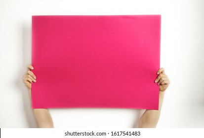 A large sheet of red paper in hands on a white background. Copy space. Woman hold blank card. 
