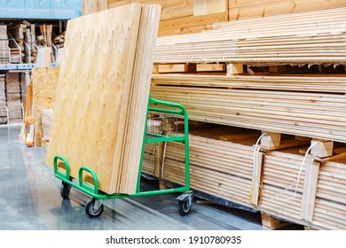 Large sheets of plywood lie on a transport cart in a building supplies store. Copy space