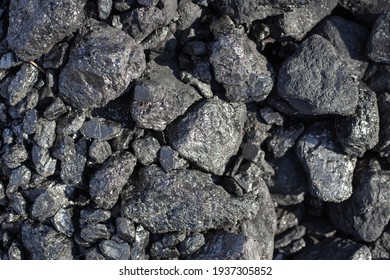 Large shiny lumps of coal. Mineral, mineral fuel for home stoves and boilers in a country house. Natural background.