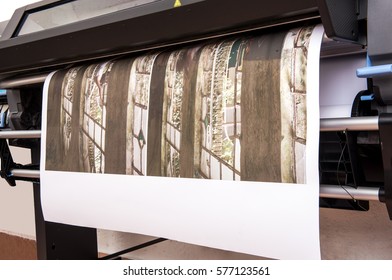 Large size wide format professional printer working printing out photo on roll paper