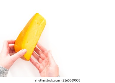 Large Slice Of Smoked Gouda Cheese On A White Background.