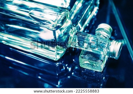 Large and small bottles of vodka on a glass table. Sale of alcoholic beverages at the bar. Close-up