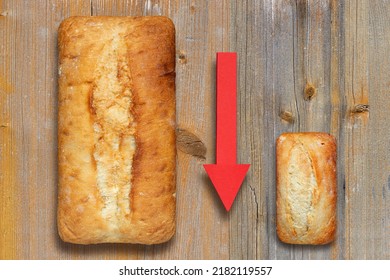 Large And Small Loaf Of Wheat Bread With Red Arrow Pointing Down. Concept Of Wheat Shortage, Food Crisis And Famine. Rising Wheat Prices