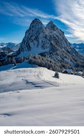 The large and small Mythen mountains photographed on a snowshoe tour at Haggenegg. With a freshly snow-covered landscape and the approaching sunset. Grosser Mythen, Kleiner Mythen, im Kanton Schwyz.