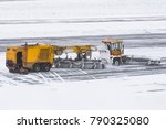 Large snow plowing machine at work on the road during a snow storm in winter