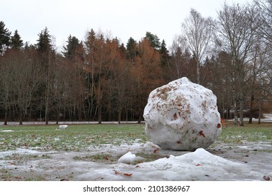 Large Snowball During The Winter. Melting Snow, And Green Grass Visible. Stockholm, Sweden. 