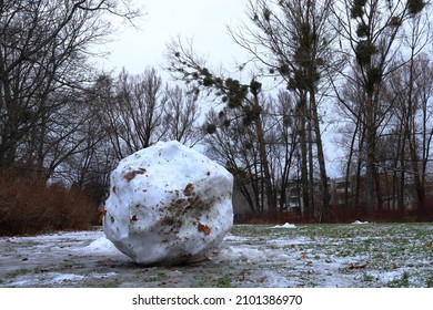 Large Snowball During The Winter. Melting Snow, And Green Grass Visible. Stockholm, Sweden. 