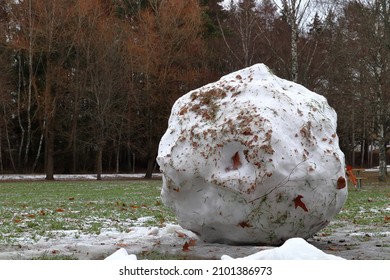 Large Snowball During The Winter. Melting Snow, And Green Grass Visible. Stockholm, Sweden. 