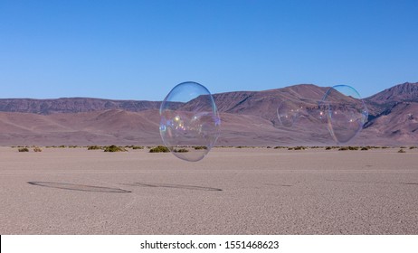 Large soap bubble floating above Alvord desert with Steens mountains in the background