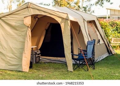 Large spacious tent setup with chairs, table and camping fridge at the campsite in caravan holiday park in Australia - Powered by Shutterstock