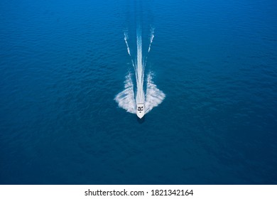 Large speedboat moving at high speed at sunset. Travel - image.  Drone view of a boat  the blue clear waters. Aerial view luxury motor boat.