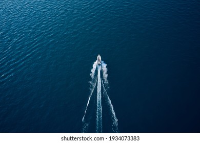 Large speedboat moving at high speed at sunset. Travel - image. Drone view of a boat the blue clear waters. Aerial view luxury motor boat. 