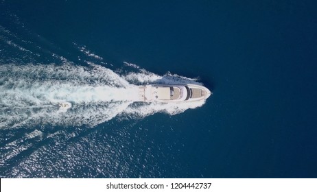 Large speedboat roaring across the Mediterranean Sea - Top down aerial image.