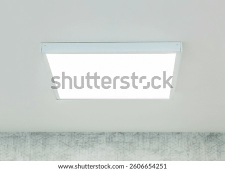 Large, square, led ceiling panel provides bright, even illumination in a contemporary room, enhancing visibility and creating a modern ambiance against a backdrop of patterned wallpaper