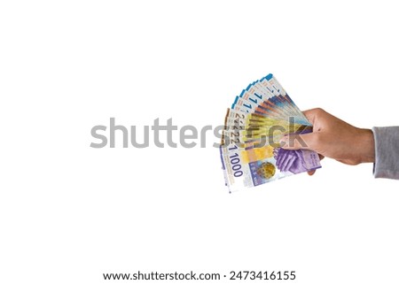 Large stack of 100, 200 and 1000 Swiss francs cash banknotes or bills held by Caucasian male hand. Close up studio shot, white background.