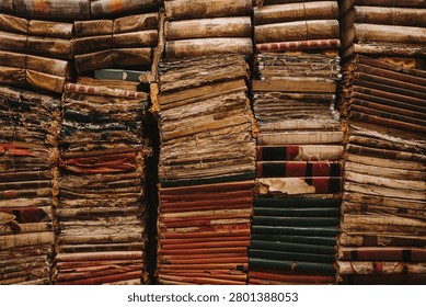 Large Stack Of Antique Leather Bound Books With Weathered Spines In A Historic Archive Or Library