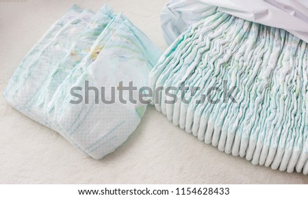 A large stack of baby diapers, close-ups, diaper packaging