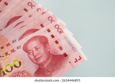 Large stack of Chinese yuan banknotes on blue background. Copy space. Close up.