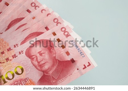 Large stack of Chinese yuan banknotes on blue background. Copy space. Close up.