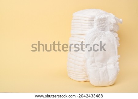 A large stack of disposable panties on a yellow background. copy space