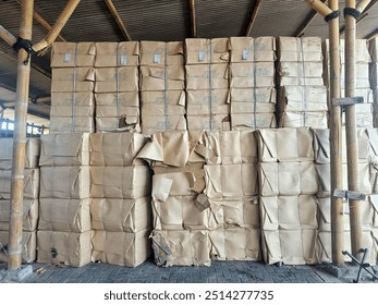 A large stack of pulp paper boxes neatly arranged in a warehouse setting, symbolising an organisation and storage solution for efficient logistics and inventory management