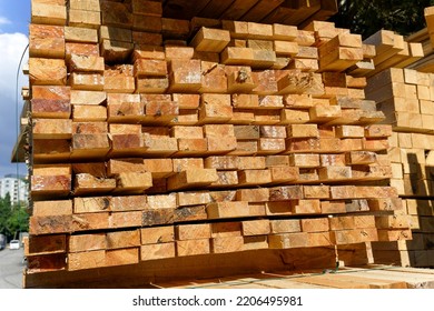 Large stack of sawn timber planks and wooden beams at a lumber yard, industrial wood material for construction and carpentry projects.