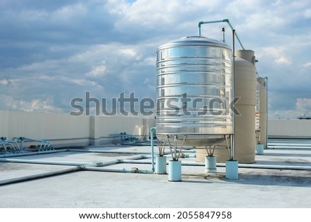 A large stainless steel water tank is mounted on top of the building.  To reserve water when the water supply does not flow