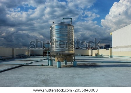 A large stainless steel water tank is mounted on top of the building.  To reserve water when the water supply does not flow